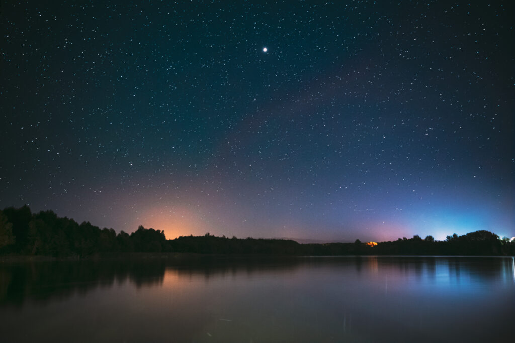 Village novoye lyadno, lyepyel district, vitebsk province, belarus. real colorful night stars above lepel lake. natural starry sky background backdrop landscape